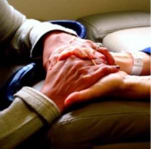 Person holding hands with a hospital patient